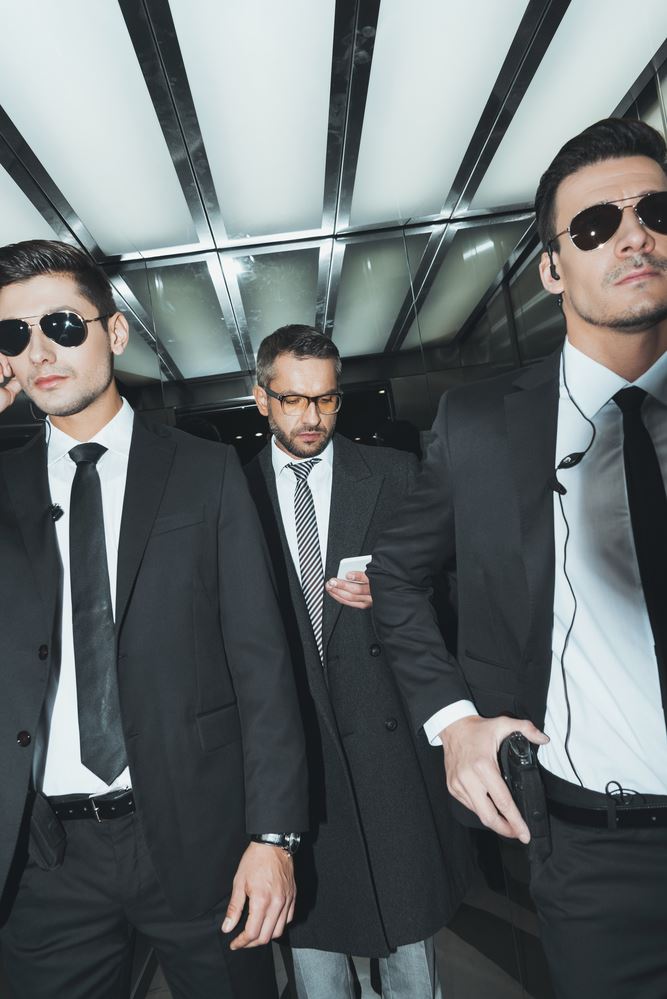 Executive bodyguards walking out of building with client