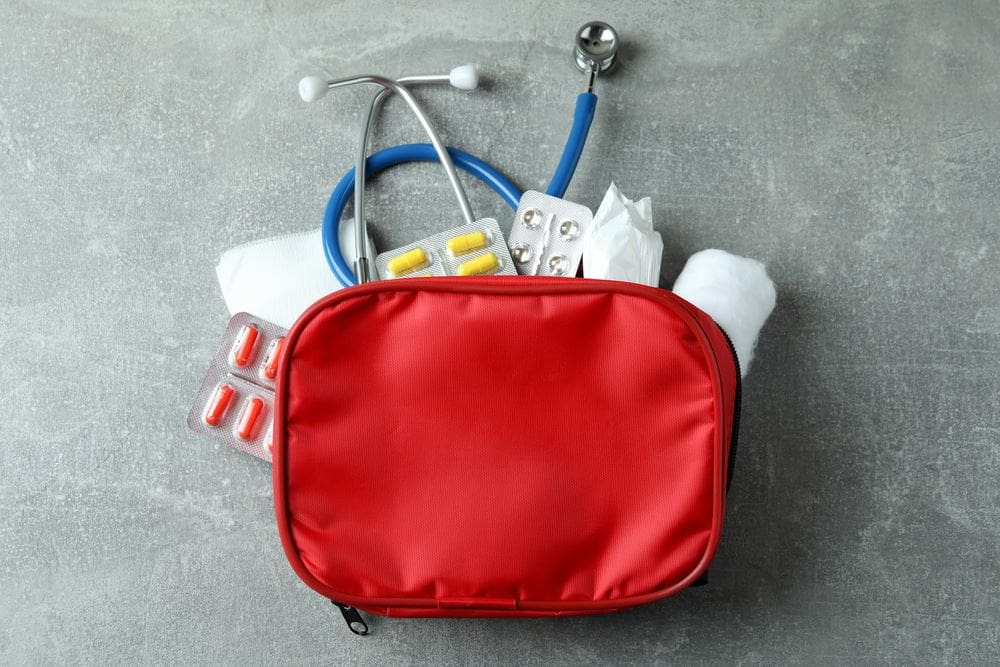 A red bag with medical supplies inside of it.