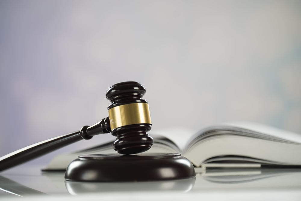 A judge 's gavel and book on top of a table.