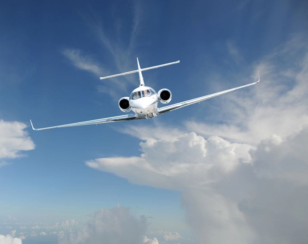 A white airplane flying through the sky