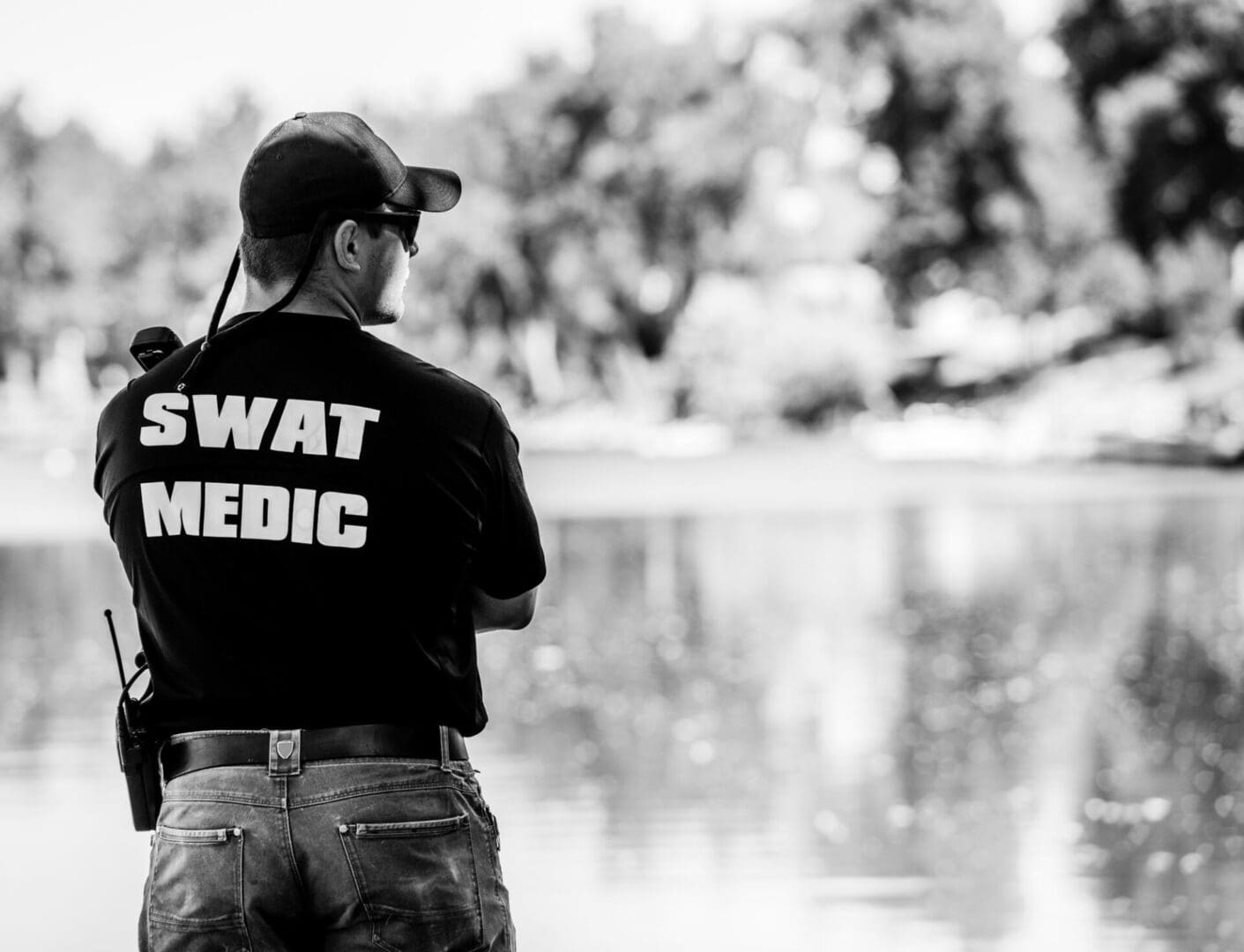 A man standing in front of water holding onto a fishing rod.